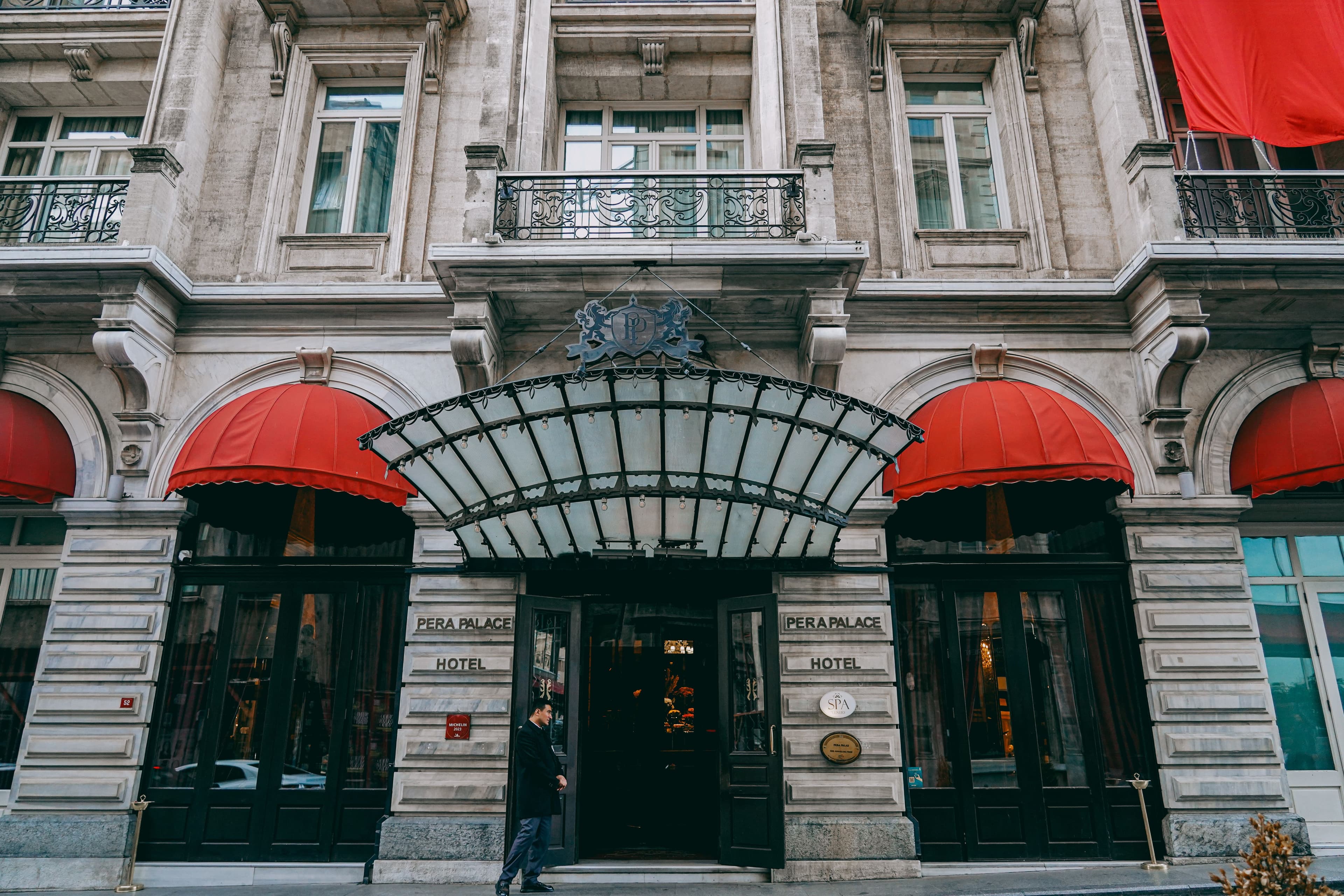 Historic Pera Palace Hotel entrance with red dome awnings and an ornate glass canopy.